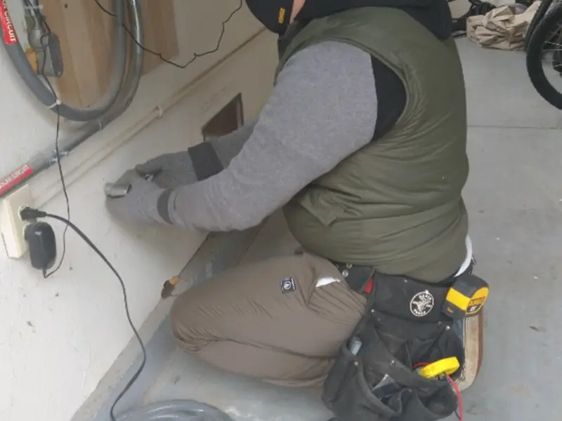 Electrician performing outlet wiring in a Texas garage